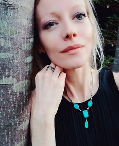 model by a tree wearing a mood ring and mood necklace