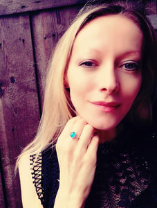 a model wearing a sterling silver celtic mood ring showing a blue mood meaning