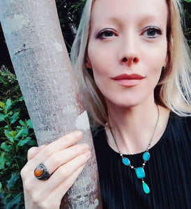model by a tree wearing a mood necklace and a mood ring