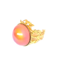 Load image into Gallery viewer, a mood ring with a circular mood turning an orange color and a gold brass band