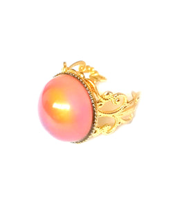 a mood ring with a circular mood turning an orange color and a gold brass band