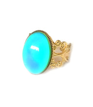 Load image into Gallery viewer, a mood ring with a turquoise mood color and golden brass band