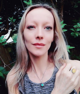 blonde model wearing an oval mood ring and a vintage mood necklace in the garden