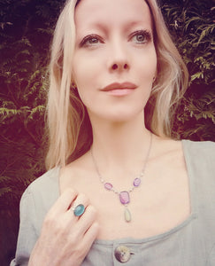 model wearing a mood ring and a mood necklace in the garden