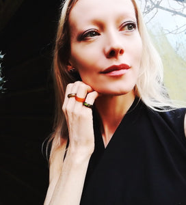 blonde model wearing a red, green and black agate mood ring 