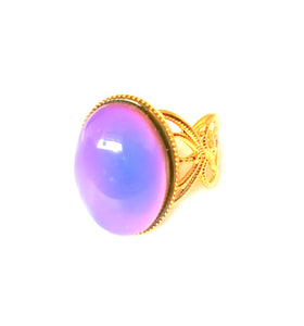 a mood ring turning purple set on a golden shade adjustable band