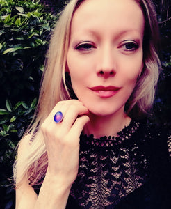 a model wearing a sterling silver mood ring with a purple color meaning