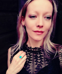 a model wearing a sterling silver mood ring showing a blue mood meaning